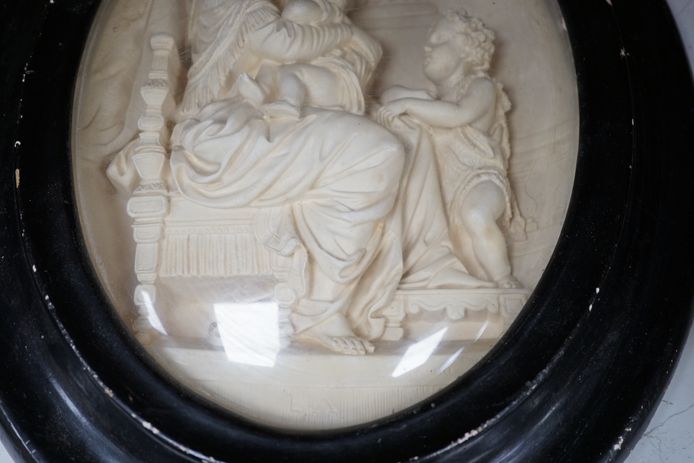 A pair of framed plaster ovals of the Madonna and Child with John the Baptist and the 'Descent from the Cross' 41x33cm